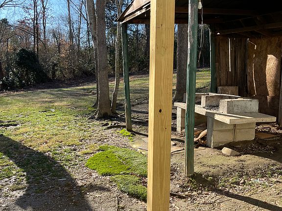 Back of the house covered patio and small grill in separate small building