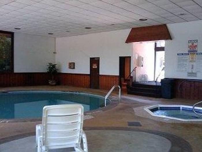 Pool area with hot tub and sauna