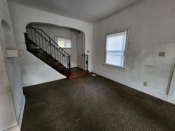 More living rm with guest coat closet and staircase to 2nd floor bedrooms