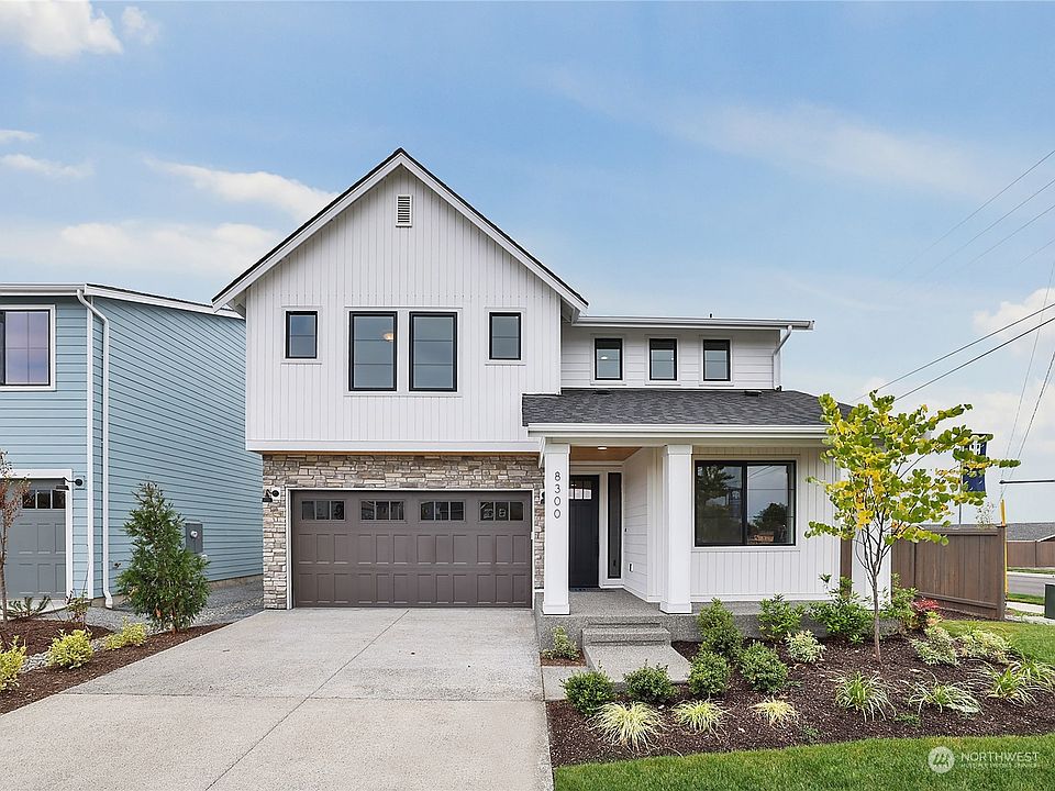 Plan 2415 Elevation B 2 car. Photo of another home built in Soundview. Lot 12 will  include the 3rd garage bay>