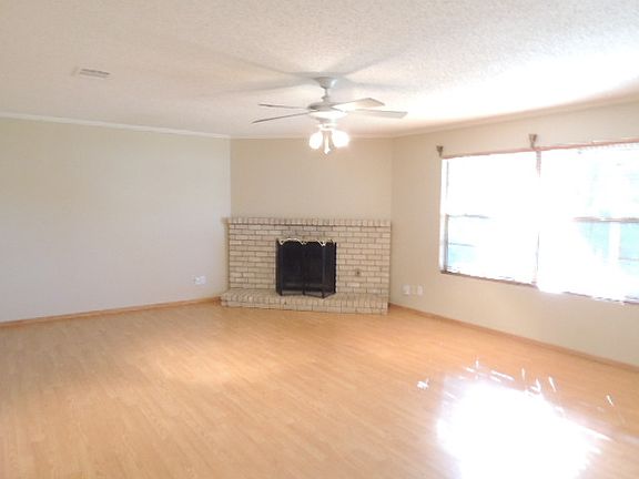 Spacious living room has laminate wood floors with a fireplace.