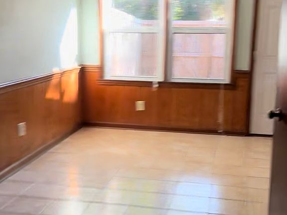 dining area with eye view coming from den with door to closed in patio with laundry room outside.