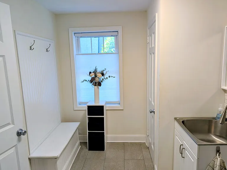 Mudroom with coat closet and utility sink