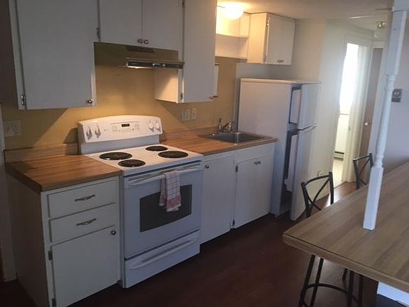 Kitchen with electric stove and refrigerator.