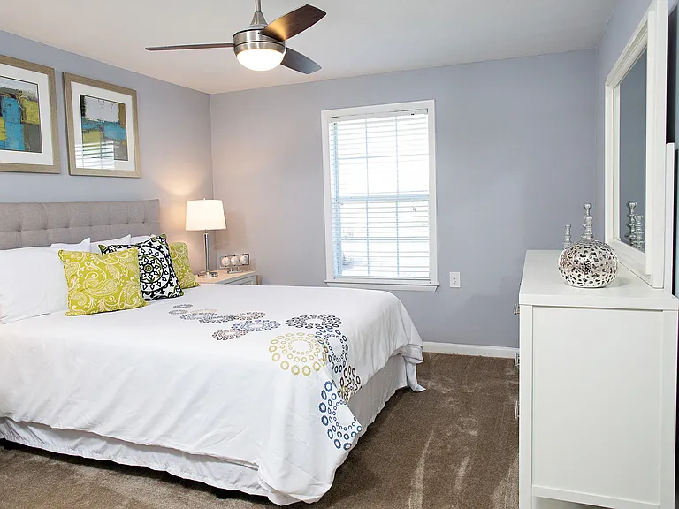 Bedroom with queen size bed, dresser and night stand.