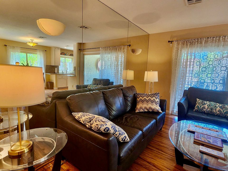 Living Area feature wood floors, leather couches, mirrored walls, tables, smart TV, fast Wi-Fi.