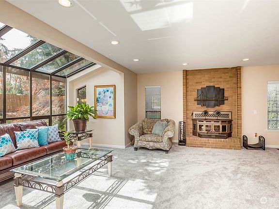 Sun-filled atrium/living room with wood-burning stove>