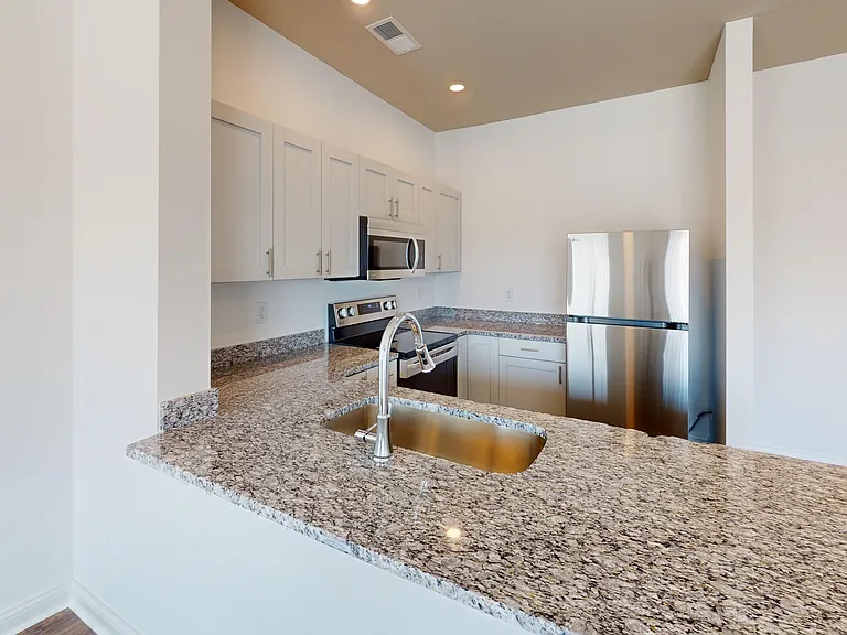 The Alred kitchen features granite countertops, a breakfast bar, and stainless steel appliances. The Alred kitchen features granite countertops, a breakfast bar, and stainless steel appliances.