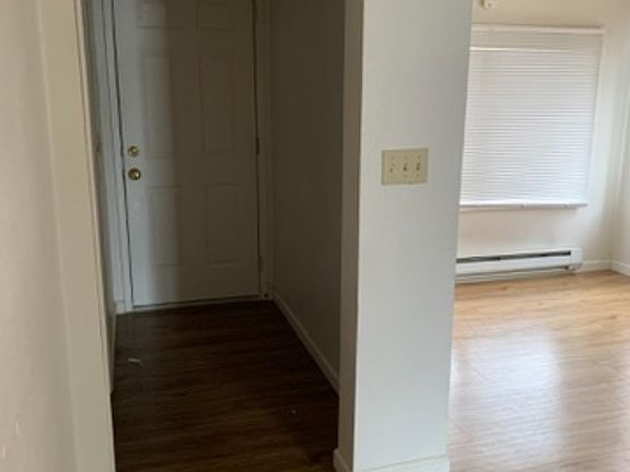 Hallway leading to laundry room, bathroom and back door. Dining area visible to the right.