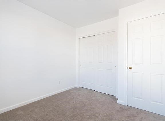 Secondary bedroom #2. Large closet and white 6-panel doors. Newer carpeting.