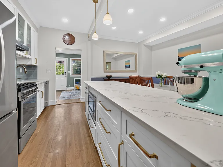 Kitchen with expansive island countertop opening to the dining room (to the right)