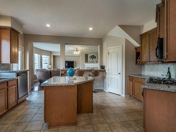 Large kitchen is spacious and complete with gas cooktop and island.