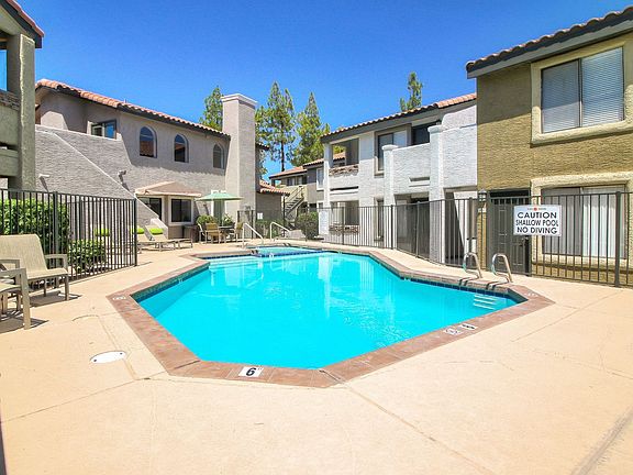 Courtyard pool and spa with long lounge chairs and umbrella-shaded picnic area.