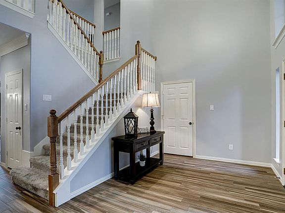 Enter the home through a solid wood door to a spacious entry with soaring ceiling. Handsome wood-look tile flooring throughout the first floor, and convenient access to the garage.
