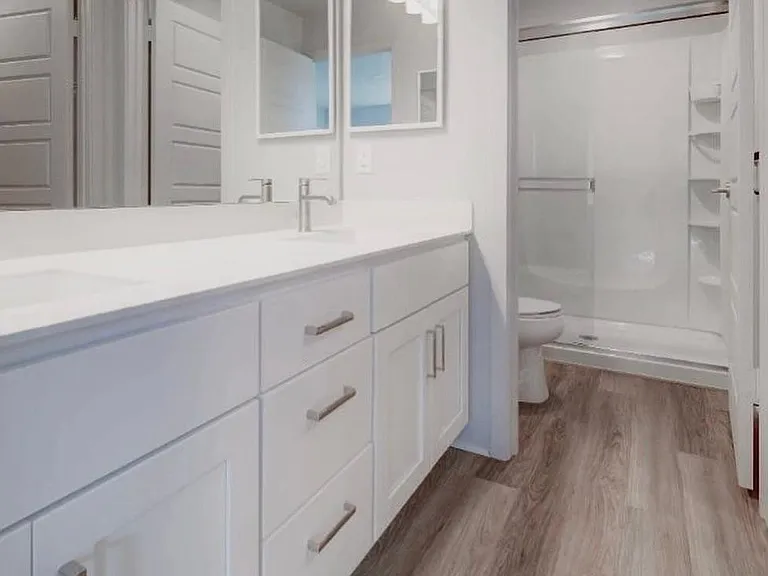 Ensuite bathroom with dual sinks/vanity, separate toilet/shower area.