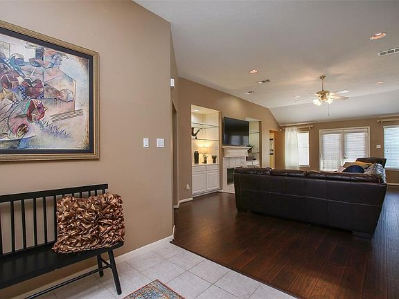Entry foyer opens into spacious family room, formal dining on right, study on left. Fresh interior paint in warm neutral beige. Beautiful hand scraped wood laminate floors installed 2017.