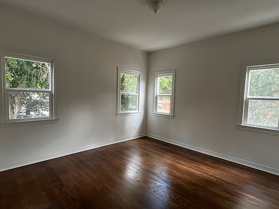 large bedroom with lots of windows, hardwood floors