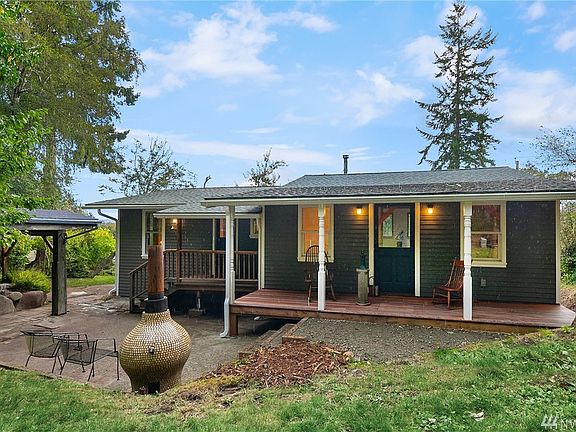 Entry patio off the entry is great for outdoor gatherings. Wood shed to left off the patio. Kitchen entry door on left, main entry on right.