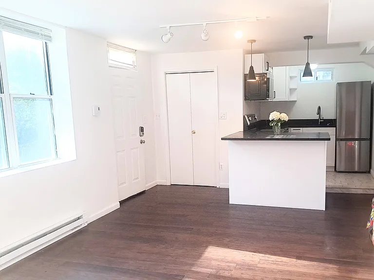 Open kitchen with eat-in counter. Front entrance on left with coat closet.