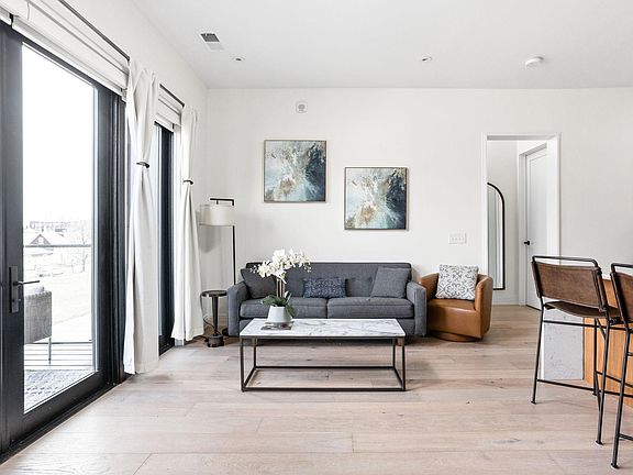 Living space filled with light from wall to wall balcony doors.