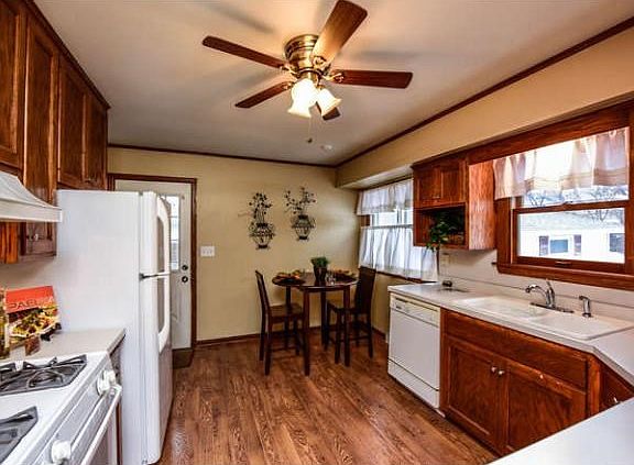 Ceiling fan, natural woodwork, and plenty og cabinet space.