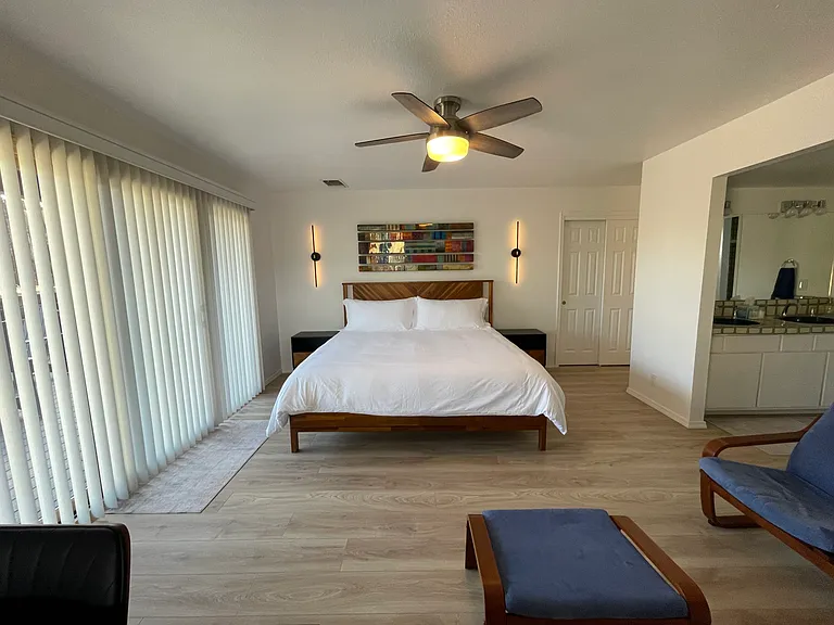 Primary Bedroom with en suite bath, modern kiva fireplace, large dedicated workspace, and patio access