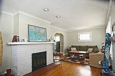Living Room. Living room w/ fireplace, wood floors & arched doorway