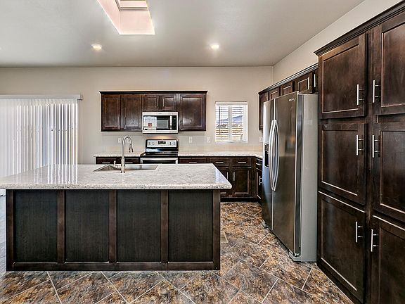 Kitchen - Solid wood cabinets & upgraded nickel hardware, upgraded stainless appliance package, center island, title back splashes, country farm sink with pull out faucet, skylight, recessed lighting.
