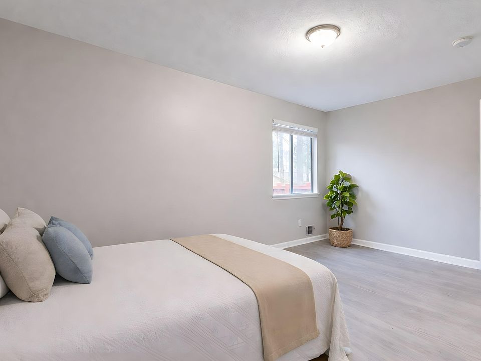 Spacious bedroom with neutral finishes, wide-plank flooring, and a large window for natural light and fresh air.