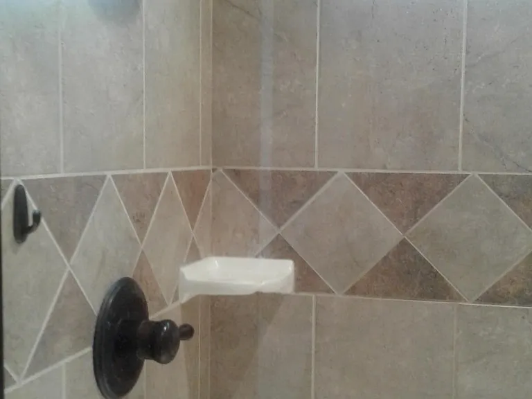 Beautiful tiled shower with updated hardware.