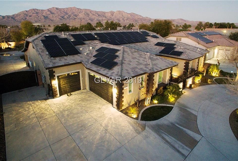 Beautifully appointed custom home built by Edward Lyons features stone accent, 3-car garage, elegant design elements with wrought iron driveway gate and courtyard gate located on just under 1/2 acre in gated community with mountain views.