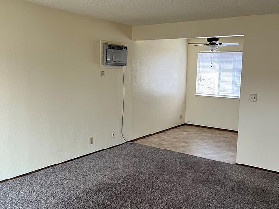 Photo from front door showing living room and kitchen dining area. Includes photo of AC.