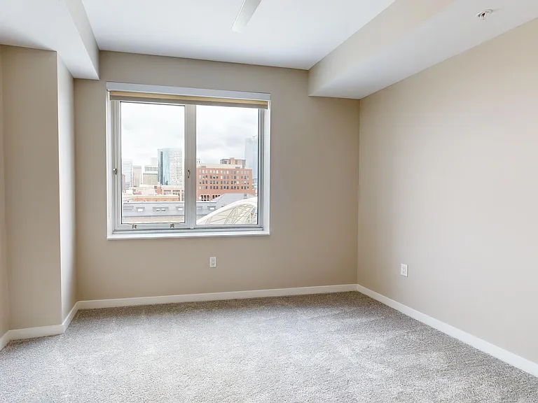 Spacious apartment bedroom with plush carpet flooring.