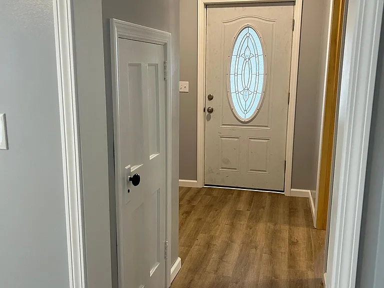 Front door and coat closet. Vinyl waterproof flooring throughout apartment.