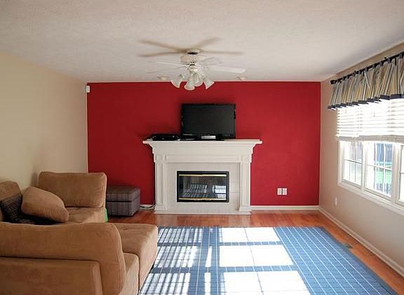Family Room with wood-burning fireplace, laminate floors and ceiling fan.
