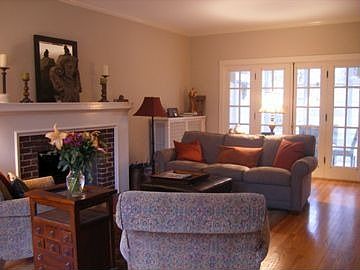 Sunlit living room with adjacent screen porch