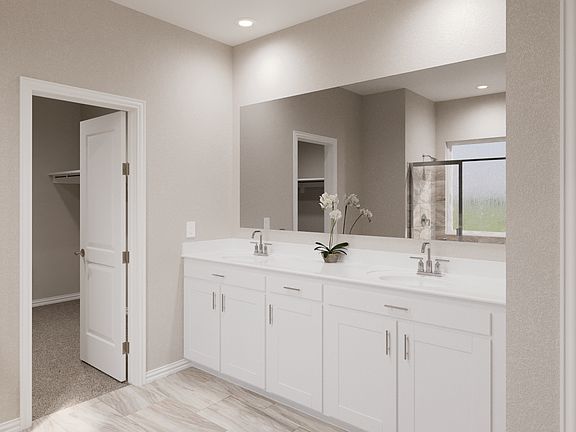 Primary bathroom with double vanity and large walk-in closet