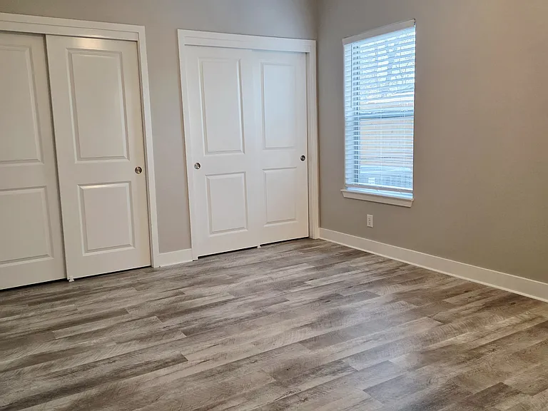 Master bedroom with dual windows and closets.