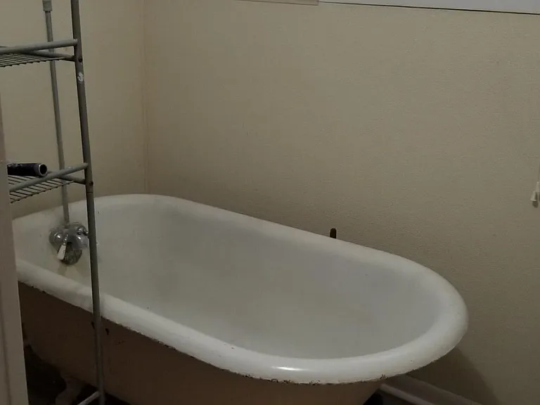 Claw foot tub with shower in bedroom wing