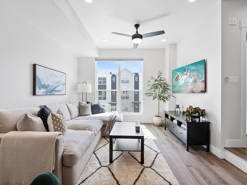Open floor plan living area with tall ceilings and natural sunlight from window