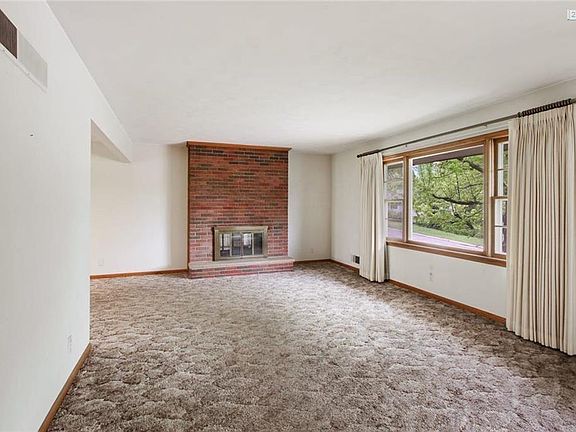 Amazing Living Room with a brick fireplace and large picture window over looking the front yard.
