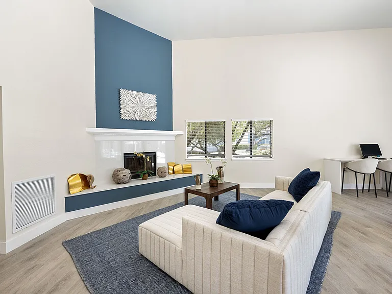 Elegant living room with a cozy fireplace, modern decor, and ample natural light, perfect for relaxation and work-from-home setup.