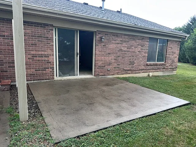 Patio area outside with a privacy fence between duplexes