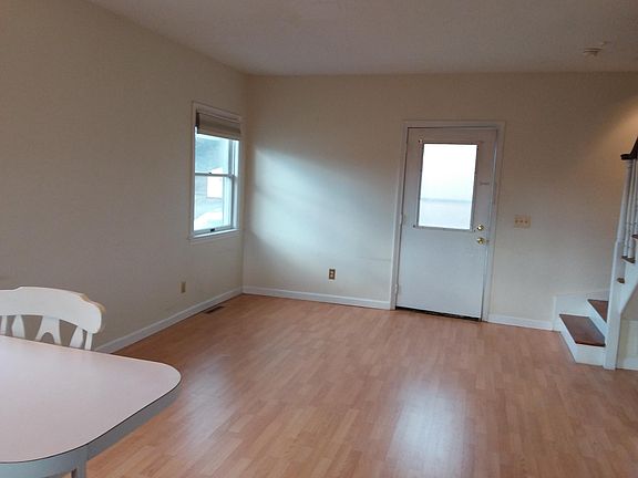 Living area approximately 12x16. Entrance door. Kitchen counter/snack bar at forefront. Stairs to 2 bedrooms and full bath upstairs.