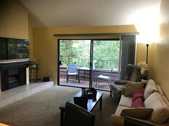 Primary Living Space w/ large sliding doors leading to balcony with lush green view.