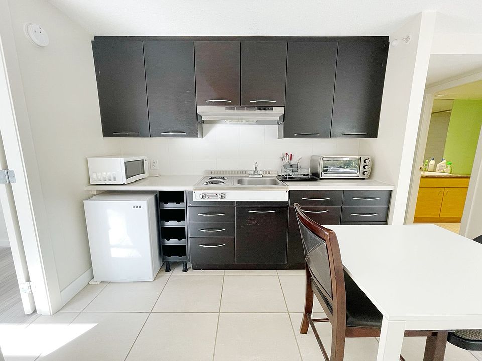 Kitchen equipped with range, oven, microwave, and compact refrigerator