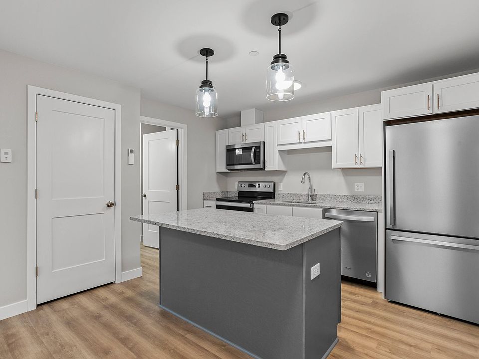 Efficient kitchen with full appliance package, granite island, and ample storage.