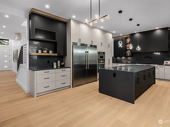 Chef's kitchen with large waterfall island, full height cabinets and high end appliance package>
