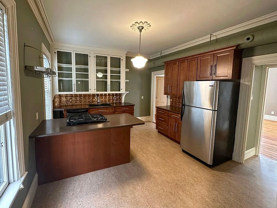 Open and airy kitchen with stainless fridge, stove and dishwasher