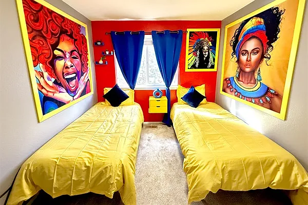 A bright and colorful twin bedroom adorned with vibrant artwork and yellow bedding, ideal for relaxation.